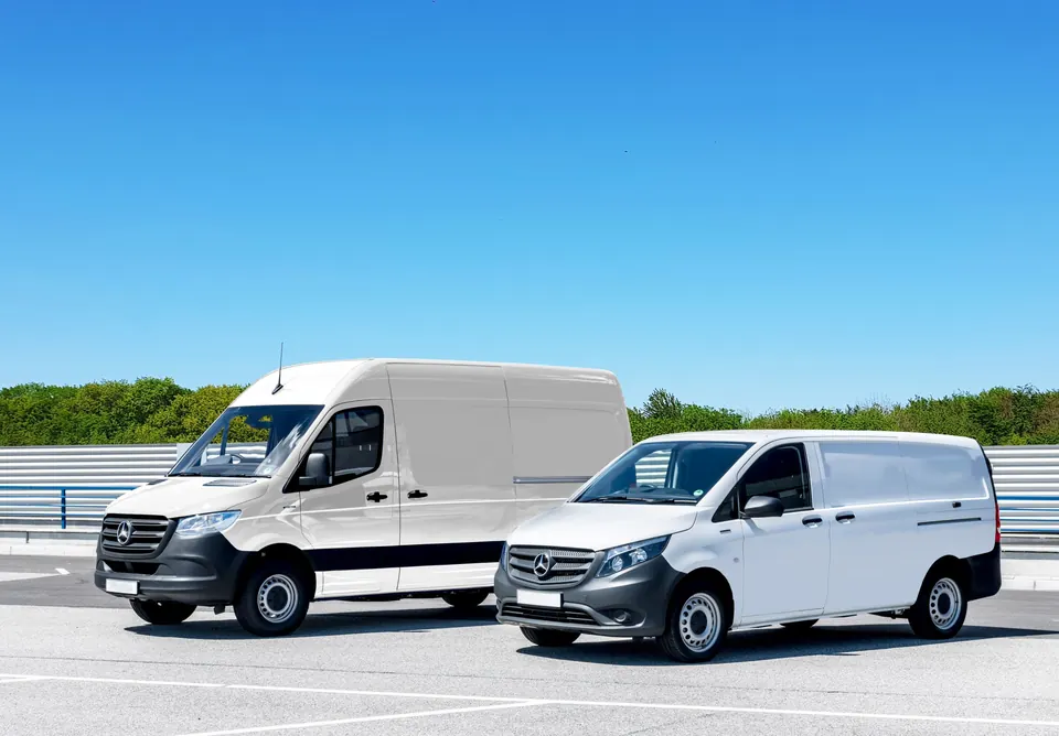 Two white work vans parked in a lot